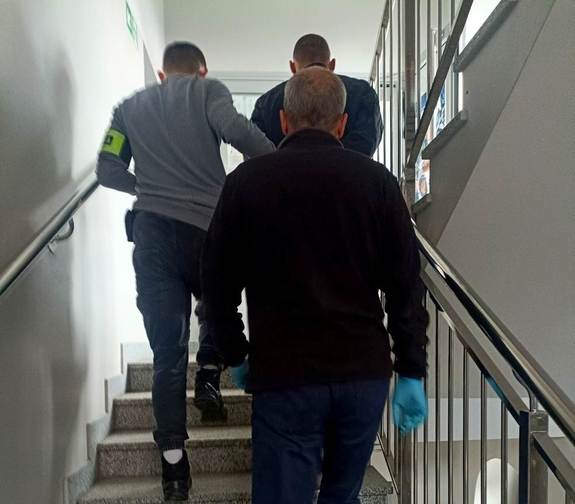 policjanci prowadzą zatrzymanego