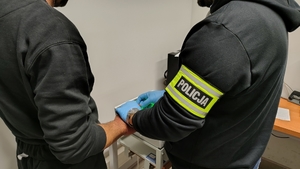 policjant pobiera daktyloskopie zatrzymanemu