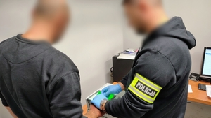 policjant pobiera daktyloskopie zatrzymanemu