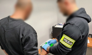 policjant pobiera daktyloskopię zatrzymanemu