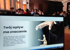 ekran laptopa, w tle młodzież