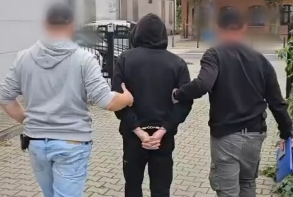 policjanci prowadzą zatrzymanego