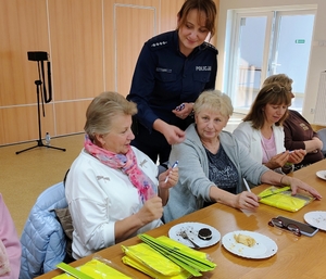 policjantka przekazuje odblaki seniorom