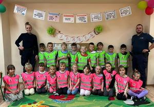 uśmiechnięci policjanci z grupą przedszkolaków