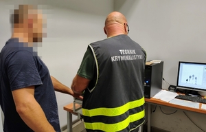 policjant pobiera daktyloskopie zatrzymanemu
