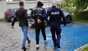 policjanci prowadzą zatrzymanego