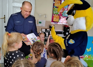 policjant pokazuje dzieciom książeczkę