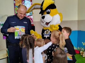 policjant pokazuje dzieciom książeczkę