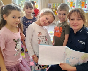 policjantka pokazuje dzieciom książeczkę