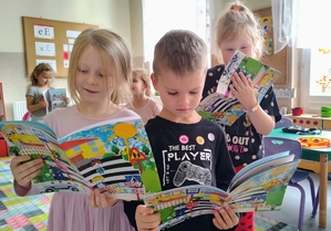 dzieci oglądają książeczkę