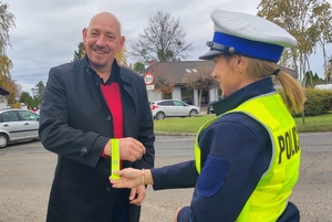 policjantka przekazuje opaskę odblaskową mężczyźnie