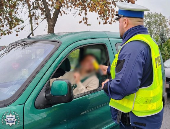 policjant bada kierowcę na trzeźwość