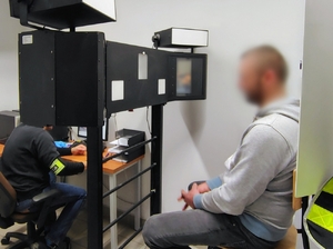 mężczyzna siedzi w pomieszczeniu technika kryminalistyki