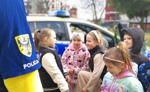 grupa dzieci przy policyjnym radiowozie i maskotce