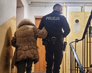 policjant prowadzi seniorkę