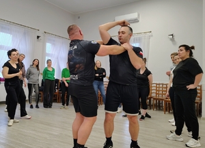 dwóch mężczyzn demonstruje chwyty samoobrony