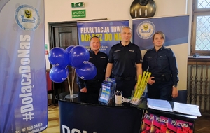 policjanci na tle niebieskich banerów