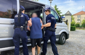 policjanci prowadzą poszukiwanego mężczynę