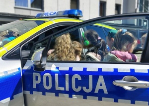 dzieci wsiadają do radiowozu