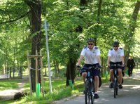 policjanci na rowerach patrolują miejski park