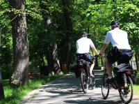 policjanci na rowerach patrolują miejski park