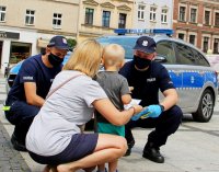 policjanci rozdają ulotki dzieciom