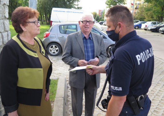 dzielnicowy przekazuje ulotki seniorom