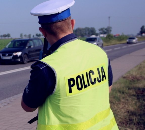 policjant kontroluje prędkość poruszających się pojazdów