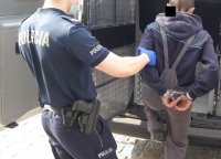 policjanci prowadzą zatrzymanego