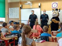 policjanci prowadzą pogadankę z dziećmi w szkole