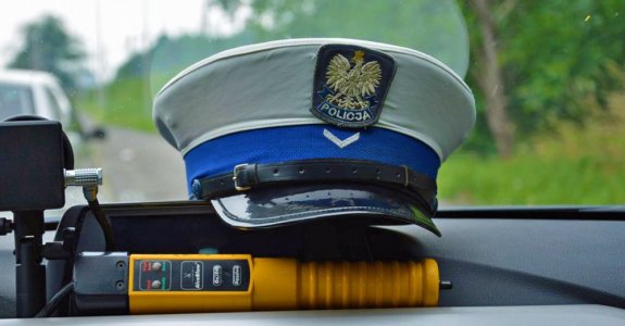 urządzenie do badania stanu trzeźwości i czapka policyjna na podszybiu w radiowozie