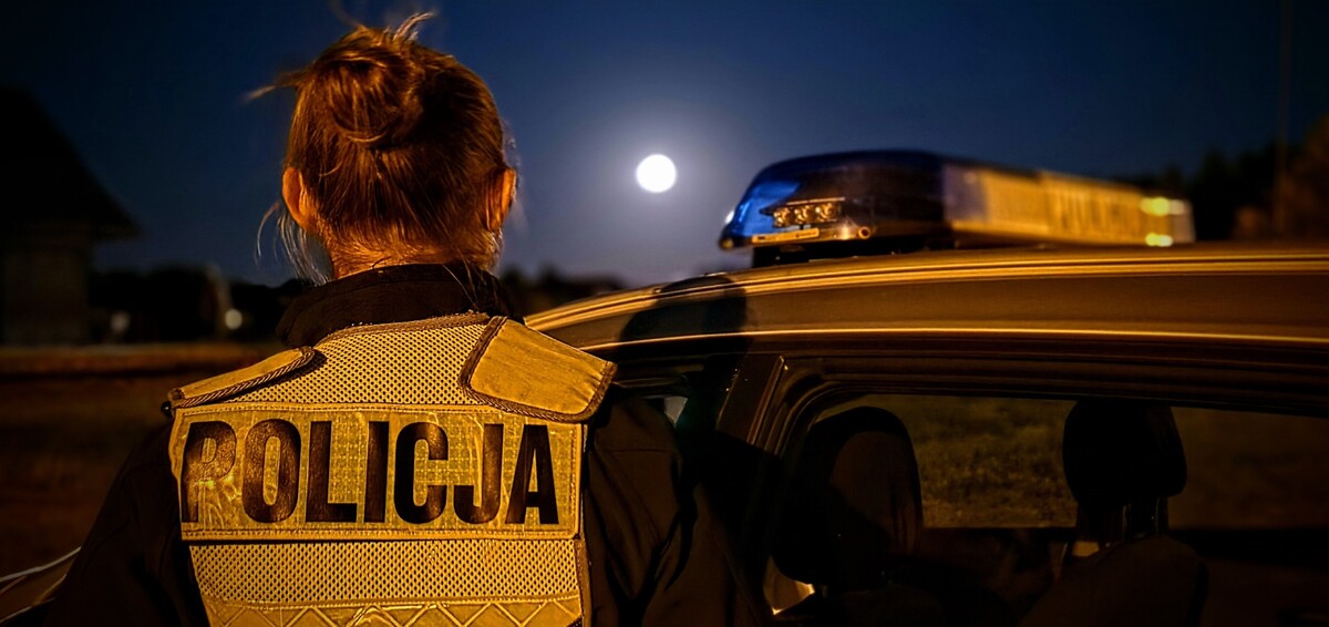 Zdjęcie: policjantka stojąca tyłem. 