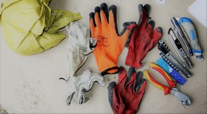Zdjęcie przedstawia odzyskane mienie, tj. rękawice robocze oraz narzędzia.