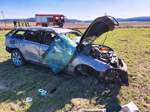 Zdjęcie przedstawia samochód po wypadku drogowym, z licznymi uszkodzeniami.
