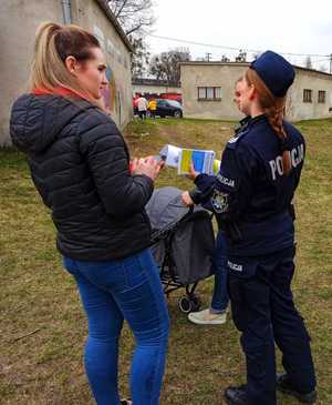 Zdjęcie przedstawia policjantkę rozmawiającą z grupką osób z Ukrainy.