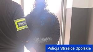 Zdjęcie kolorowe przewarstwiające zatrzymanego mężczyznę prowadzonego przez kryminalnych.