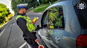 Zdjęcie kolorowe przedstawiające Policjanta przeprowadzającego badanie trzeźwości