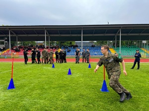 Zdjęcie kolorowe przedstawiające ucznia klasy mundurowej biorącego udział w konkurencji sportowej.