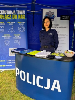 Zdjęcie kolorowe przedstawiające policjantkę przy stanowisku promocyjnym.