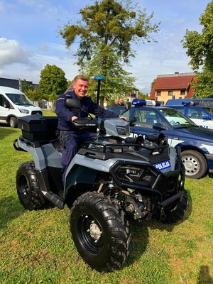 Zdjęcie kolorowe przedstawiające policjanta na quadzie.