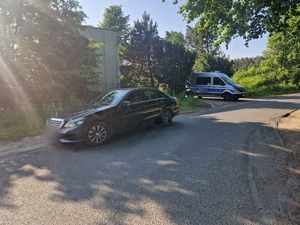 Zdjęcie kolorowe przedstawiające pojazd osobowy i radiowóz.