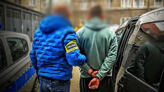 Zdjęcie kolorowe przedstawiające policjanta z zatrzymanym.