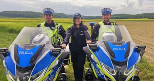 Zdjęcie kolorowe przedstawiające 2 policjantów na motocyklach i policjantkę.