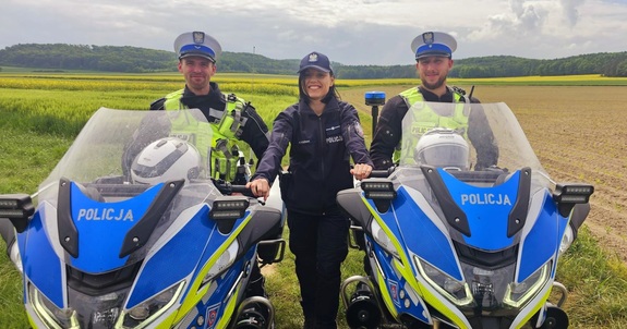 Zdjęcie kolorowe przedstawiające 2 policjantów na motocyklach i policjantkę.