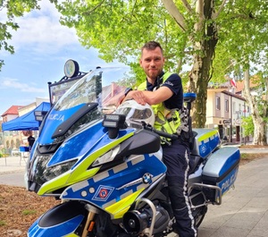 Zdjęcie kolorowe przedstawiające policjanta na motocyklu.