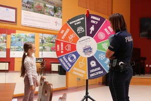 Zdjęcie kolorowe przedstawiające policjantów z dziećmi na spotkaniu w ramach programu &quot;Kręci mnie bezpieczeństwo w lecie&quot;.