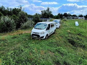 Zdjęcie kolorowe przedstawiające 2 białe busy.
