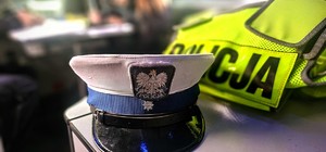 Zdjęcie kolorowe przedstawiające czapkę policjanta ruchu drogowego i kamizelkę odblaskową.