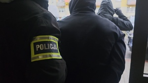 Zdjęcie przedstawia zatrzymanego z policjantem.
