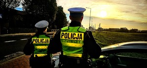 Zdjęcie kolorowe przestawia dwóch o9swóconych policjantów.
